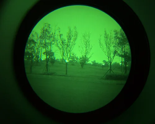 Green phosphor night vision image showing trees and a pathway